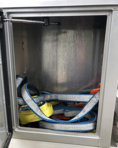 Image shows an open storage box on the side of a Fisk tank carrier propane truck.  Inside are straps.